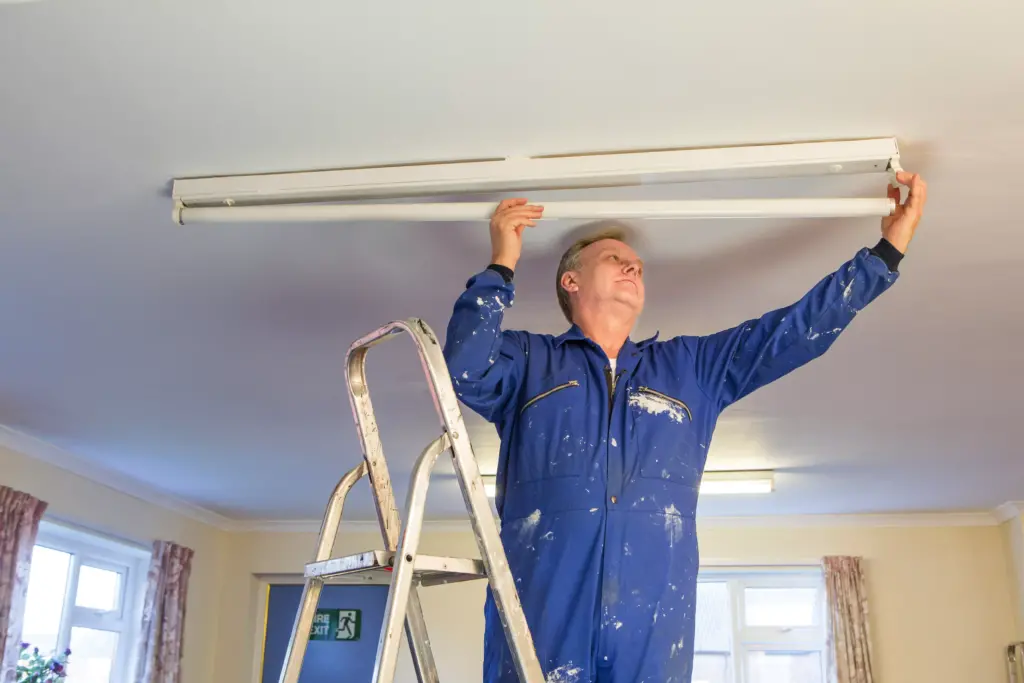 Hausmeister bei Arbeiten an der Decke